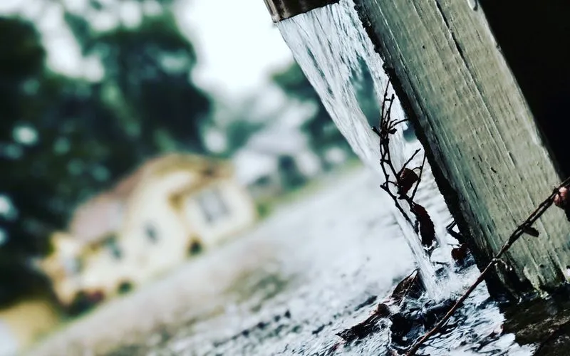 Regenwasser fließt bei starkem Regen aus einer Dachrinne