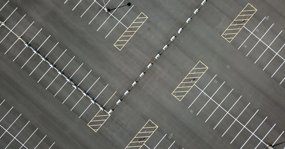 Luftaufnahme eines leeren Parkplatzes mit weißen und gelben Markierungslinien