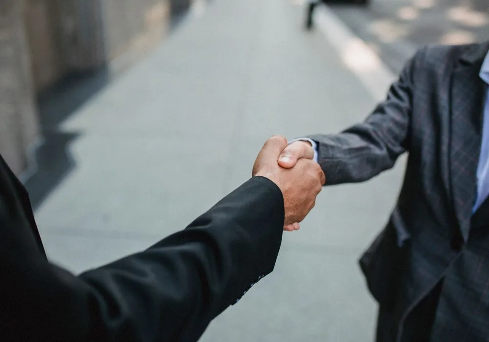 Zwei Geschäftspartner geben sich draußen die Hand